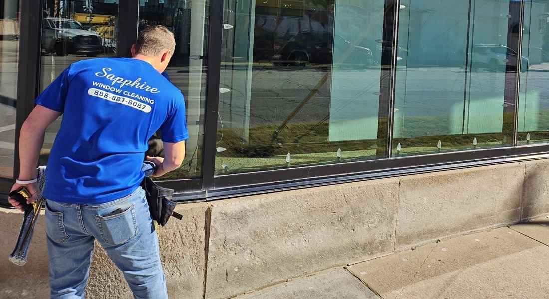 A Sapphire technician cleaning storefront windows
